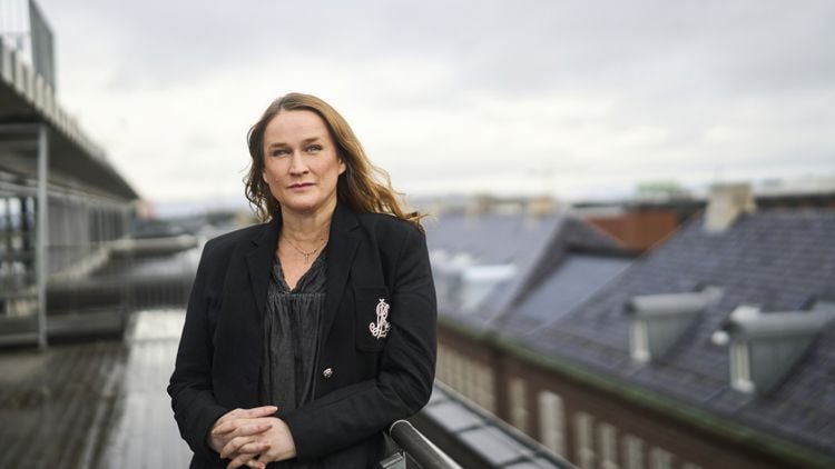 Kvinne med brunt, skulderlangt hår står ute med armene i kryss, ser ut i lufta med et ettertenksomt uttrykk