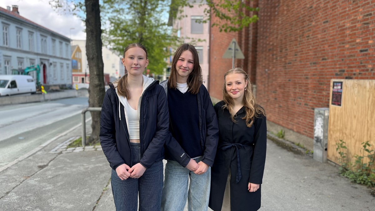 Tre unge kvinner står i gate