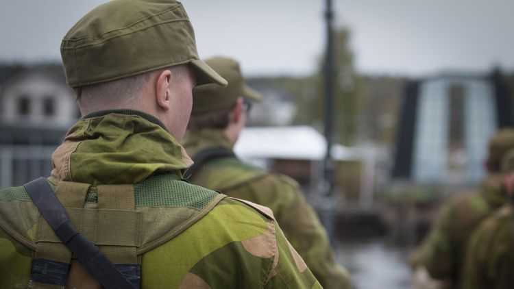Bildet viser en mann bakfra i militær uniform.